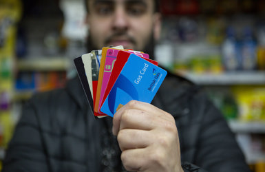 Retailer holding multiple payment cards available via Payzone