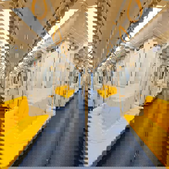Inside of an empty, modern, train carriage with bright yellow seats