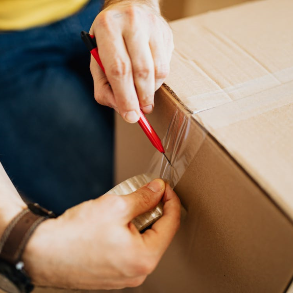 A man applying sellotape to a parcel