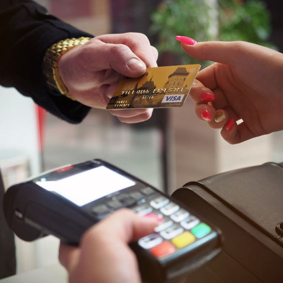 Man passing a credit card to a lady with a contactless payment device