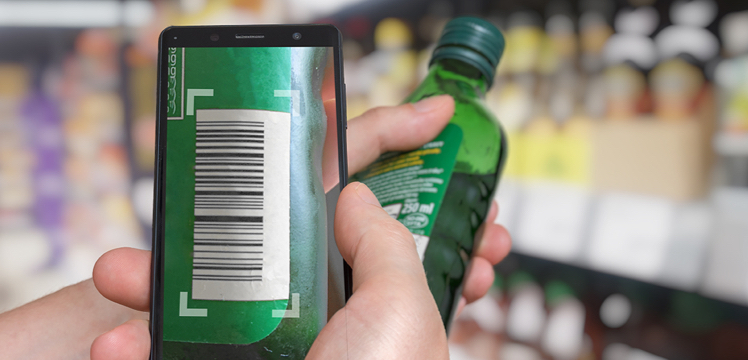 A retail employee scans a bottle of alcohol